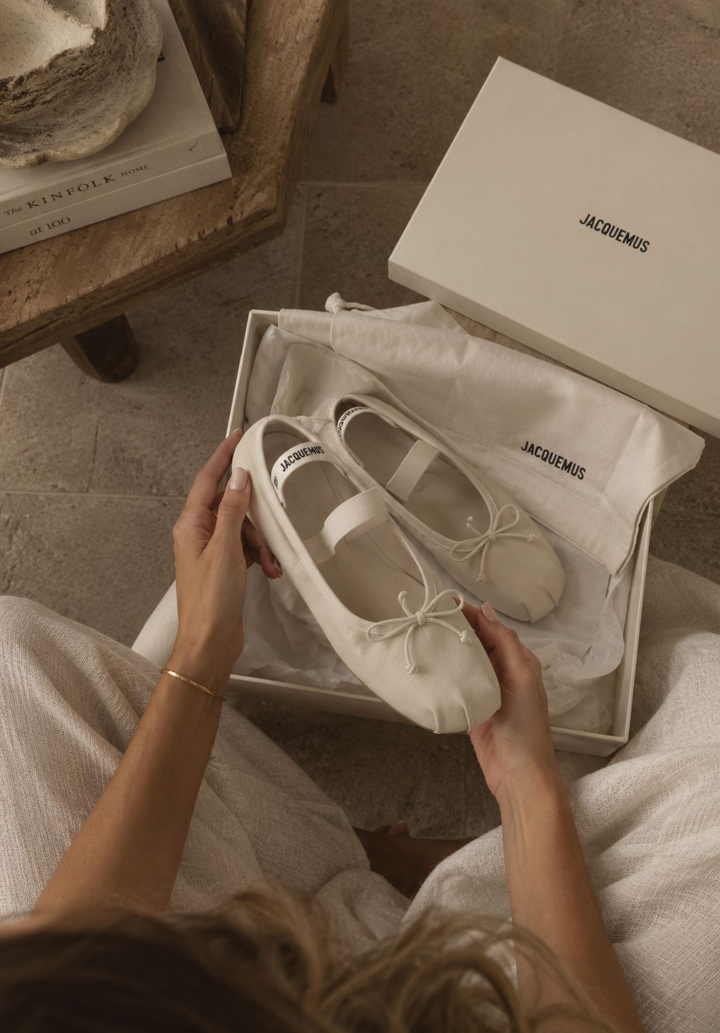 A close-up, high-angle photograph of cream-colored Jacquemus ballet flats above their open branded shoebox.